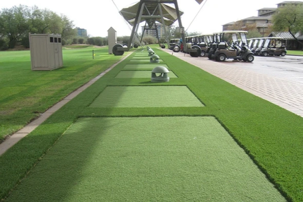 Phoenix Outdoor tee line consisting of one continuous green synthetic grass strip surrounded by trees